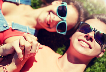 Image showing happy teenage couple lying on grass at summer