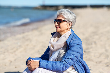 Image showing happy senior woman in jacket on beach