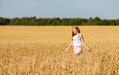 Image showing smiling young girl on cereal field in summer