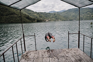 Image showing triathlon athlete jumping in water and starting with training