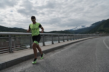 Image showing triathlon athlete running on street