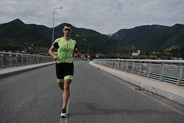 Image showing triathlon athlete running on street