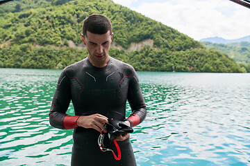 Image showing triathlon athlete getting ready for swimming training on lake