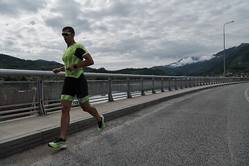 Image showing triathlon athlete running on street