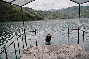 Image showing triathlon athlete jumping in water and starting with training