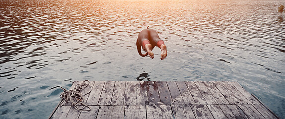 Image showing triathlon athlete jumping in water and starting with training