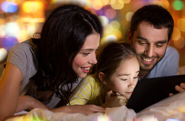 Image showing family with tablet pc in bed at night at home