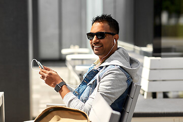 Image showing man with earphones and smartphone on city street