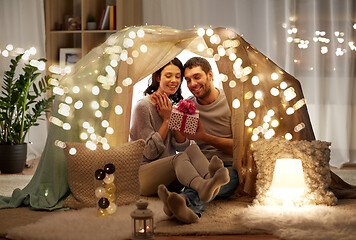 Image showing happy couple with gift box in kids tent at home