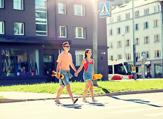 Image showing teenage couple with skateboards on city street