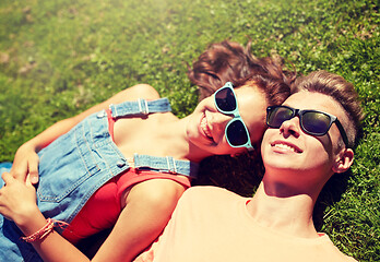 Image showing happy teenage couple lying on grass at summer