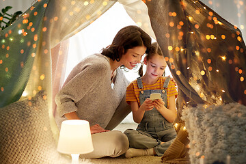 Image showing happy family with smartphone in kids tent at home