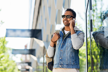 Image showing man with backpack calling on smartphone in city