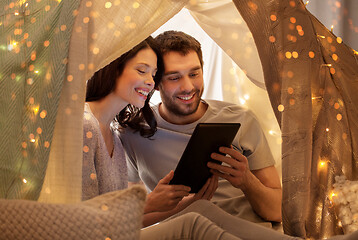 Image showing happy couple with tablet pc in kids tent at home