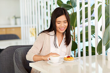 Image showing asian woman eating cake with coffee at cafe