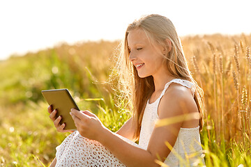 Image showing smiling with tablet computer on cereal field