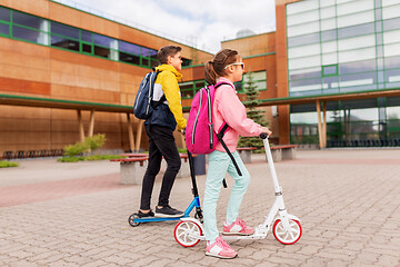 Image showing school children with backpacks riding scooters