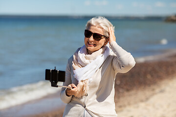 Image showing senior woman taking selfie on beach