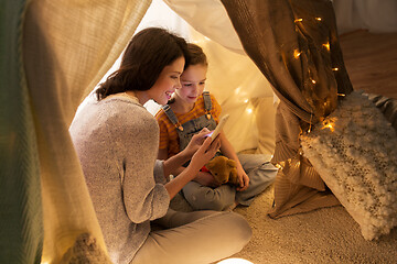 Image showing happy family with smartphone in kids tent at home