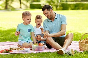 Image showing family with smartphone having picnic at park