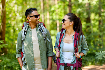 Image showing mixed race couple with backpacks hiking in forest