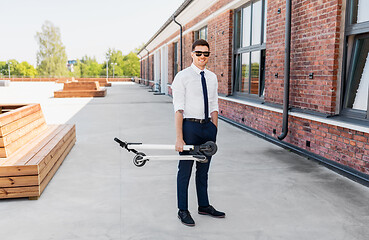 Image showing businessman with folding scooter on rooftop