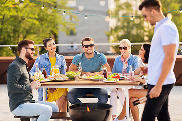 Image showing happy friends having bbq party on rooftop