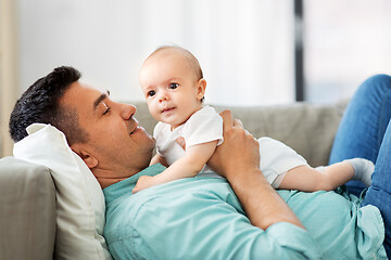 Image showing middle aged father with baby lying on sofa at home