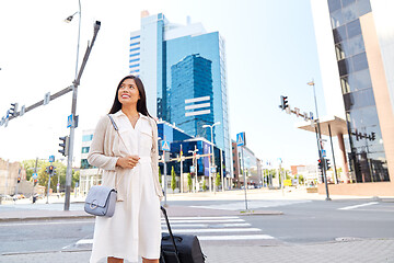 Image showing happy young asian woman with travel bag in city