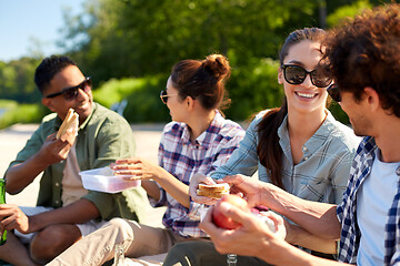 Image showing happy friends having picnic on lake pier in summer