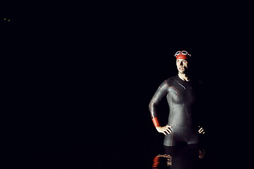 Image showing authentic triathlete swimmer having a break during hard training on night