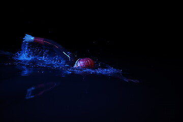 Image showing real triathlon athlete swimming in dark night