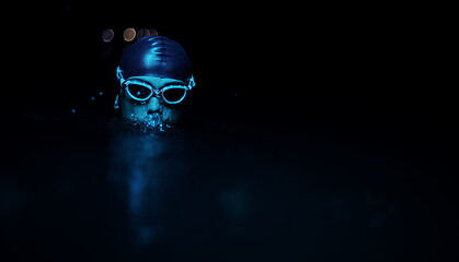 Image showing authentic triathlete swimmer having a break during hard training on night neon gel light