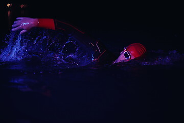 Image showing real triathlon athlete swimming in dark night