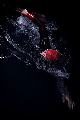 Image showing triathlon athlete swimming in dark night wearing wetsuit