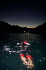 Image showing triathlon athlete swimming in dark night wearing wetsuit