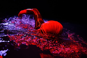 Image showing real triathlon athlete swimming in dark night