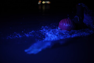 Image showing real triathlon athlete swimming in dark night