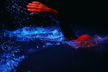 Image showing real triathlon athlete swimming in dark night