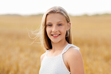 Image showing smiling young girl on cereal field in summer