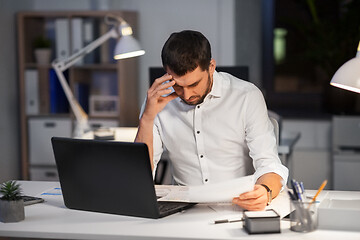 Image showing businessman with papers working at night office