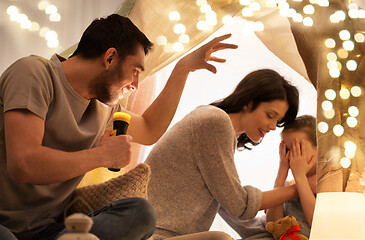 Image showing father telling scary stories to his daughter