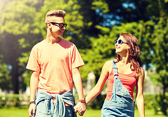 Image showing happy teenage couple walking at summer park