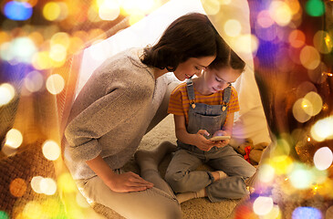 Image showing happy family with smartphone in kids tent at home