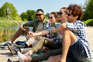 Image showing friends with drinks taking selfie on lake pier