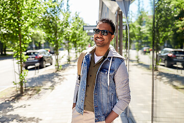 Image showing indian man with backpack walking along city street