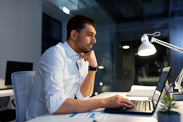 Image showing businessman with laptop working at night office