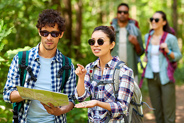 Image showing friends with map and backpacks hiking in forest