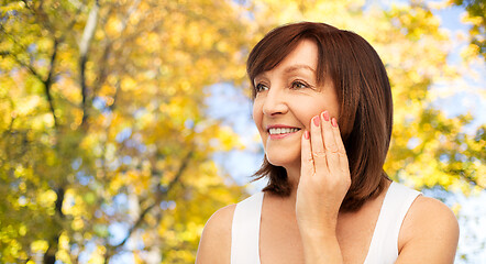 Image showing portrait of smiling senior woman touching her face