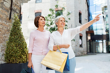 Image showing senior women with shopping bags walking in city